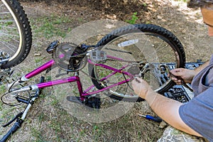 Mechanic repairman installing assembling or adjusting bicycle gear on wheel