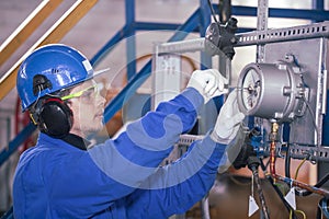 The mechanic - the repairman sets up a gas meter, locksmith repair instrumentation, worker in personal protective equipment, close