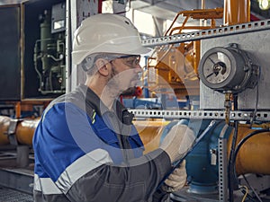 The mechanic - the repairman tightens bolts on a flanged connection of pipeline armature, operator production gas, locksmith