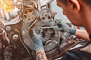 Mechanic repairs the engine of the car in a car-care center