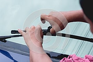 Mechanic replace windshield wipers on car. Replacing wiper blades