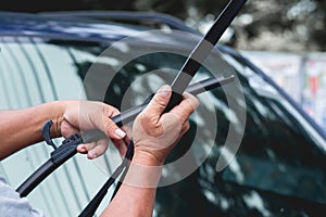 Mechanic replace windshield wipers on car. Replacing wiper blades photo