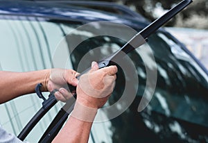 Mechanic replace windshield wipers on car. Replacing wiper blades