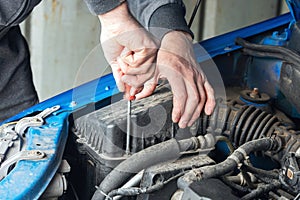 A mechanic replaces the air filter in a car