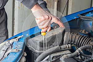 A mechanic replaces the air filter in a car