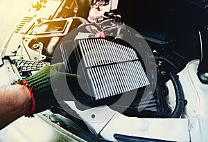 A mechanic is replacing an air filter in the engine car filter socket