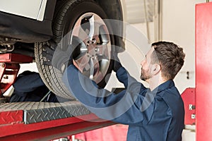 Mechanic Replacing Car Tire At Auto Repair Shop