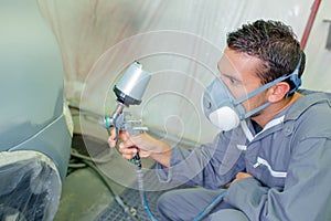 mechanic respraying car bodywork