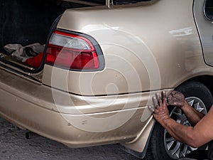 The mechanic retry remove the bumper of a car to make a new pain