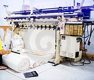 The mechanic`s hand is checking the fabric with a calculator