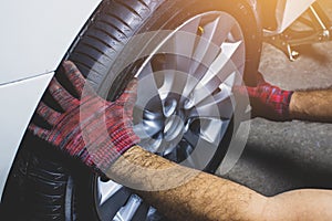 The mechanic`s hand holding alloy wheel for changing alloy wheel.