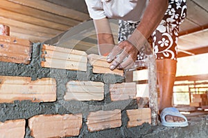 Mechanic`s hand Holding bricks in construction projects