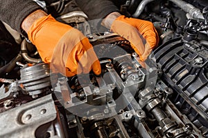 Mechanic's Hands Repairing Car Engine in Auto Service