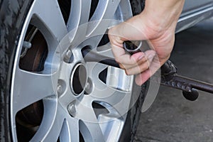 Mechanic screwing or unscrewing changing car wheel