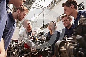 Mechanic showing engines to apprentices, low angle photo