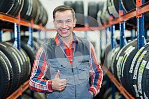 Mechanic showing thumbs up in tyre garage