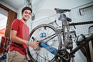 Mechanic smile while working tighten the bicycle axle with a wrench