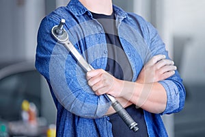 Mechanic with socket wrench, car maintenance and man in workshop for auto repair and mechanical engineering. Automobile
