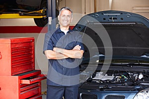 Mechanic standing in front of car