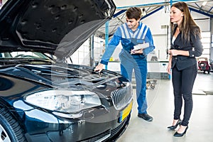 Mechanic Talking To Female Customer About Car Engine