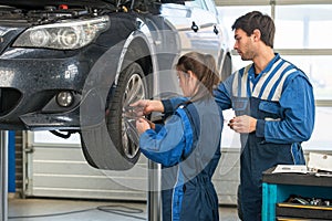 Mechanic teaching an intern in a garage photo