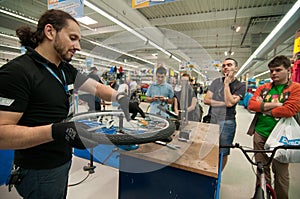 Mechanic teaching people how to true a bike wheel without a truing stand