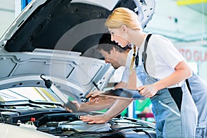 Mechanic team working in car workshop