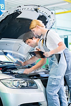 Mechanic team working in car workshop