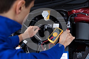 Mechanic testing car battery photo
