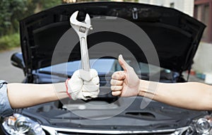 mechanic with thumbs up and tool