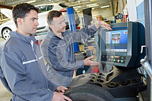 mechanic training colleague to use computerised equipment