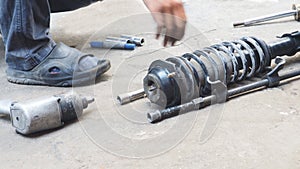 Mechanic he unscrew the shock absorber replacement