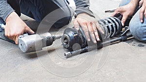 Mechanic using an air gun to unscrew with shock absorber replacement