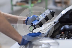 Mechanic using a battery tester