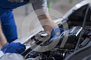 Mechanic using a battery tester photo