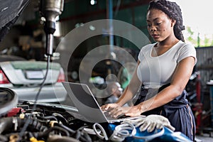 Mechanic using compute for Diagnostic  machine tools ready to be used with car. Car mechanic using a computer laptop to diagnosing