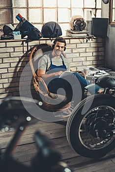 mechanic using digital tablet and headphones in repair shop