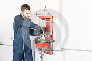 Mechanic Using Hydraulic Screwdriver To Assemble Car Shock Absorber