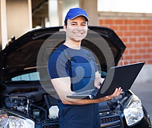 Mechanic using a laptop computer to check a car engine