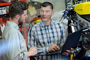 mechanic using laptop computer to check engine