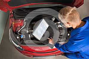 Mechanic Using Laptop To Repair Car