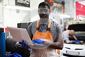 Mechanic using a laptop to work in service