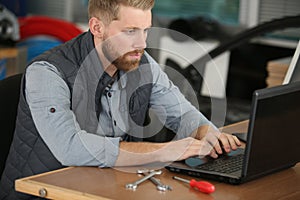 mechanic using laptop in workshop