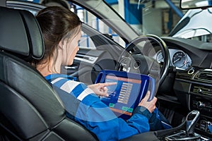 Mechanic Using Tablet Computer In Car At Garage