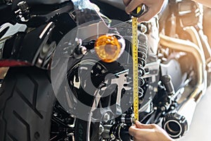 mechanic using tape measure set up suspension sag Compression and Rebound on motorcycle at garage, repair and maintenance