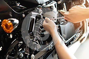 Mechanic using Tools set up suspension sag Compression and Rebound on a motorcycle in garage