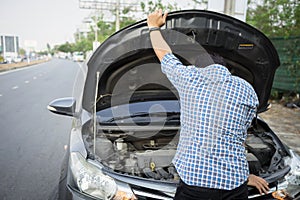Mechanic wearing gloves open car hood checking car engine oil on the road after car breakdown problem