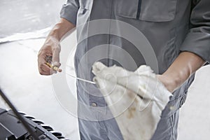 Mechanic Wiping Down Dipstick