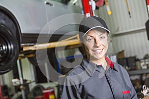 Mechanic woman working on car in his shop