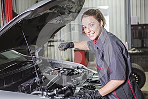 Mechanic woman working on car in his shop